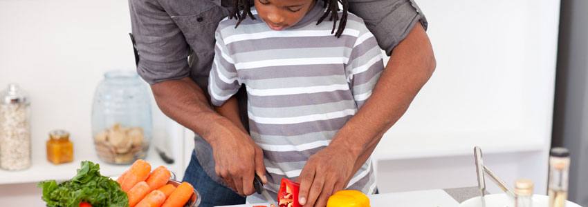 Un homme cuisine avec son enfant